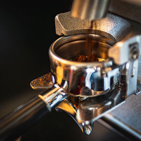 Frisch gemahlener Kaffee fällt in den Siebträger der Espressomaschine