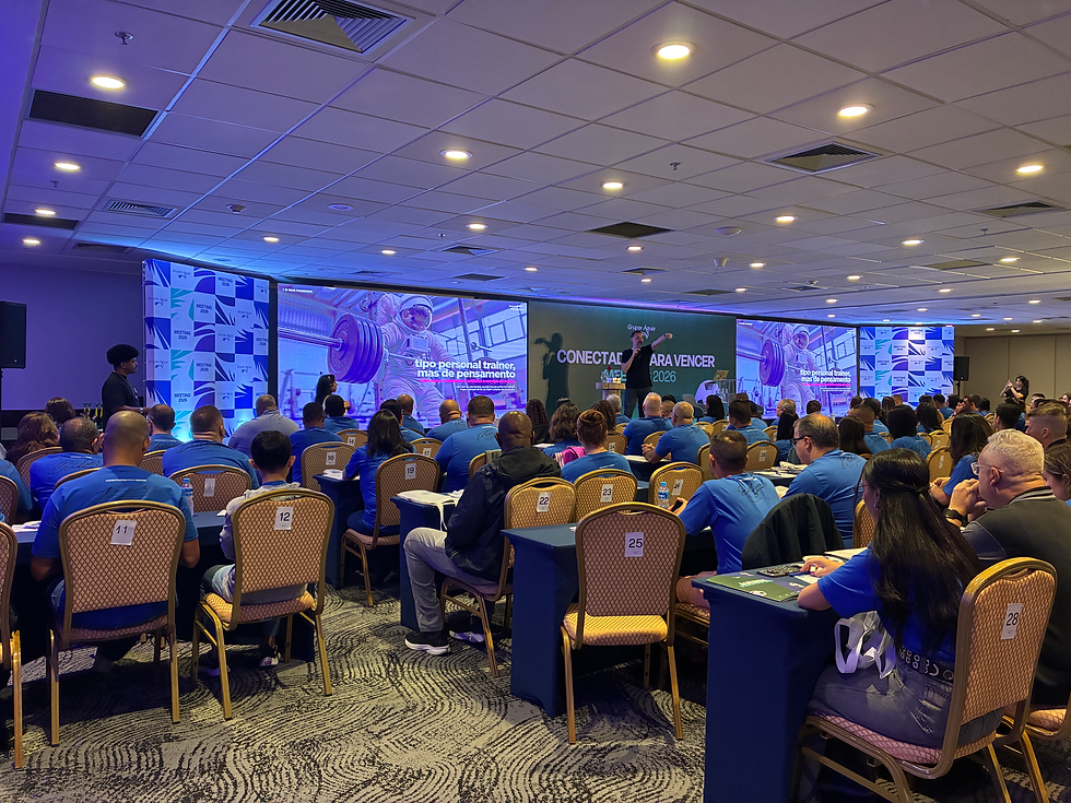 Palestra acontecendo ao fundo e com pessoas sentadas ao redos