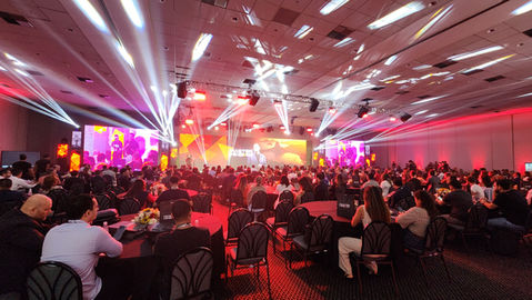 Convenção corporativa realizada em ambiente profissional com painel de LED de alta definição, iluminação cênica, sonorização profissional e participantes acompanhando apresentações em um evento empresarial no Rio de Janeiro