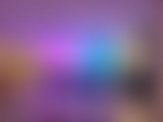 Montagem de evento corporativo em ambiente interno com um grande painel de LED de alta resolução ao fundo, palco baixo revestido em preto e sistema de sonorização com caixas acústicas de coluna nas laterais. Iluminação técnica em tons de roxo e azul.