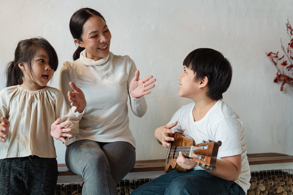 son is playing the ukulelel and mother and daughter are singing the clapping