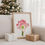 Thumbnail: Amaryllis Glee fine art watercolor print framed in natural wood frame resting on chair