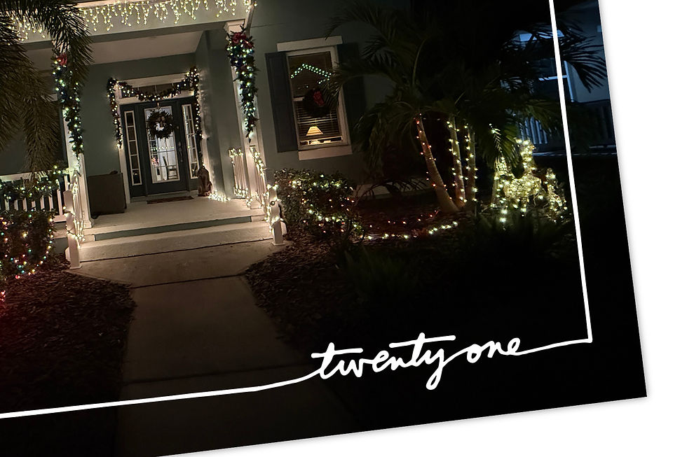 Cozy porch at night lit with multicolored Christmas lights, wreath on door, glowing reindeer decoration, "twenty one" text on black border.