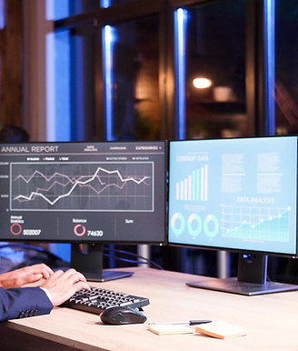 business-manager-working-two-screen-setup-late-night-office.jpg