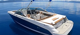 White and blue recreational boat floating on calm lake water