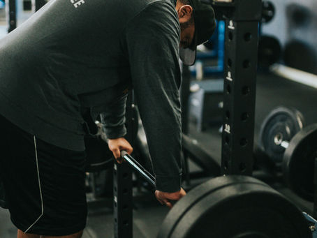 Old man struggling after liftin weight in gym