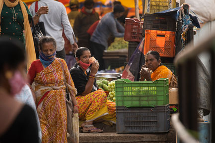 Two vegetable sellers taking a break in a busy KR Market, Bangalore