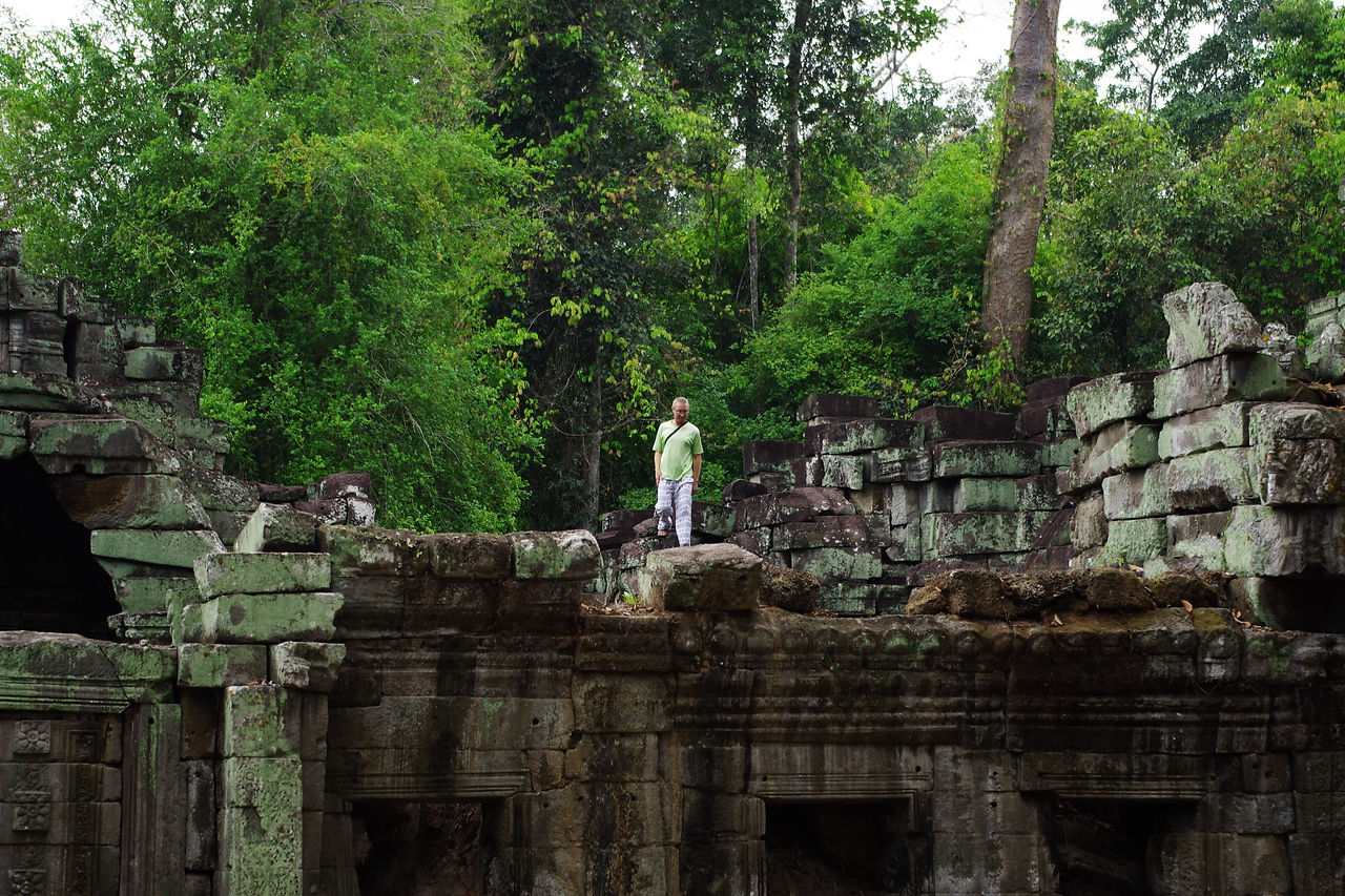 Homme escaladant le toit du Sanctuaire de Preah Khan. Comportement risqué et déplacé. Interdit de surcroît.