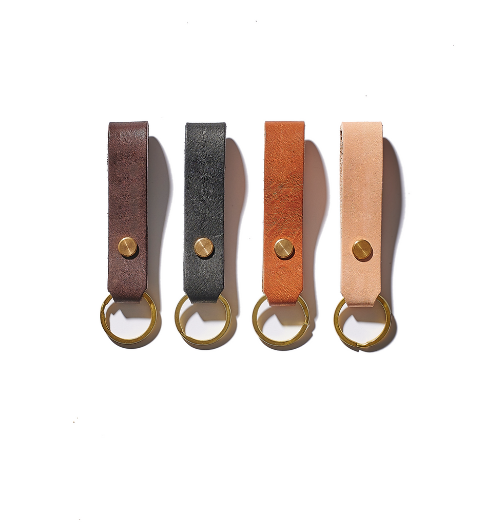 Vier Leder Schlüsselanhänger in verschiedenen Farben auf weißem Hintergrund, THE ORGANIZER.