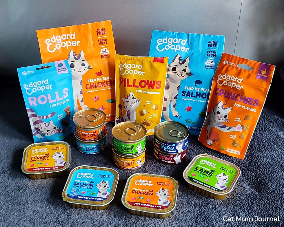 Various Edgard Cooper cat food bags and cans on a table.