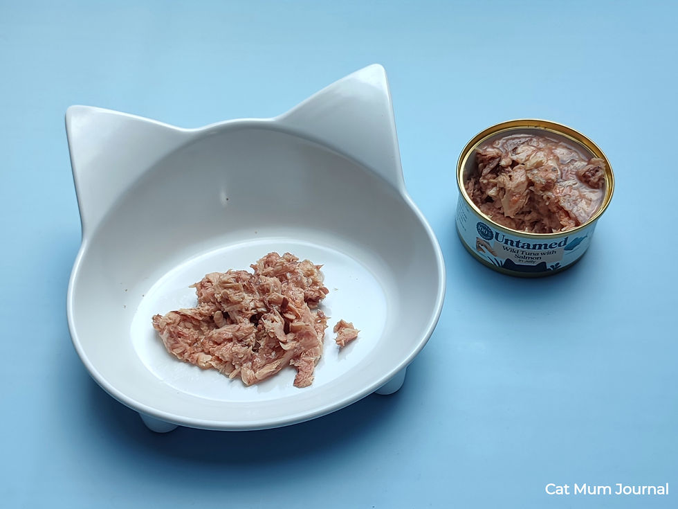 White bowl with tuna beside an open Untamed Wild Tuna with Salmon tin.
