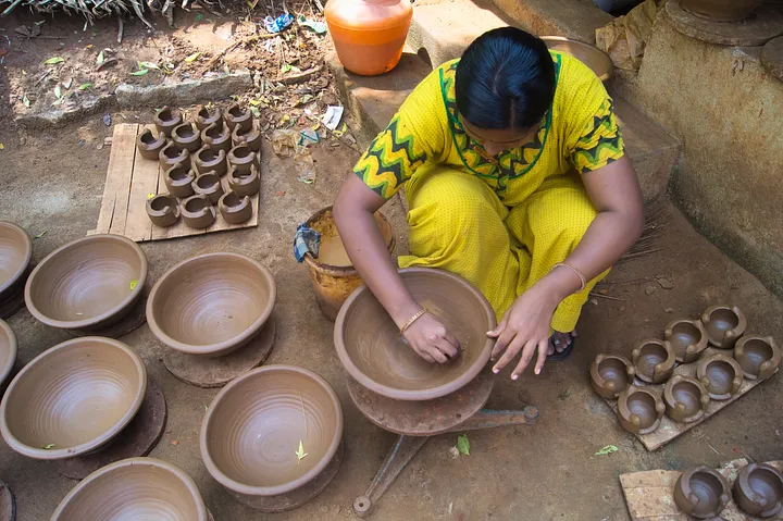 a woman correcting imperfections on the surface of clayworks