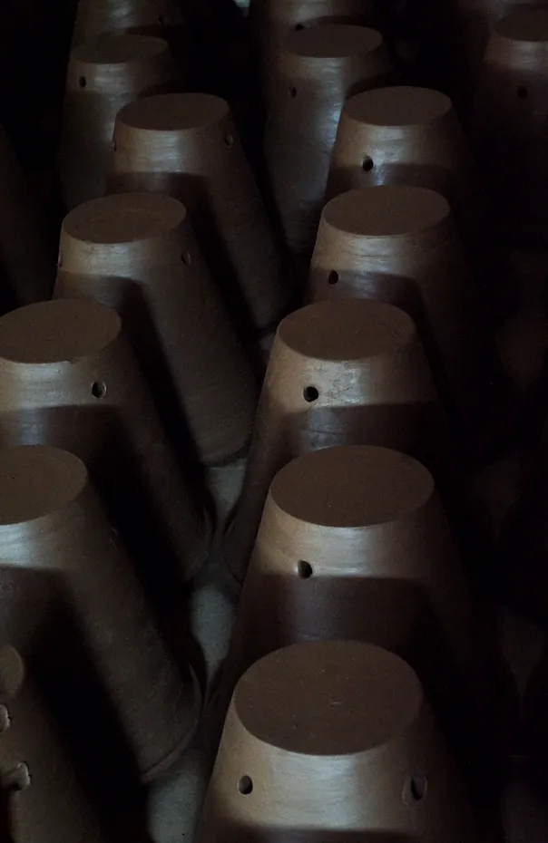 shaped clay plantpots being dried indoors 