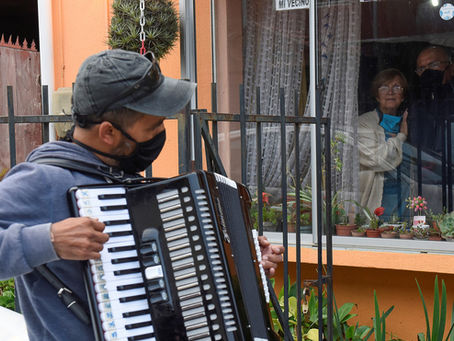Un chileno toca el acordeón frente a la ventana de sus padres para animarlos en la cuarentena por el