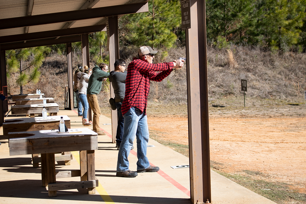 Old man shooting a pistol at a outdoor gun range