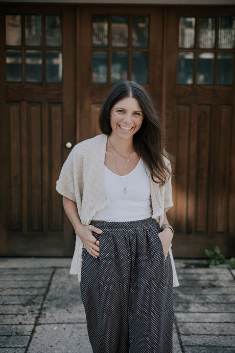 Smiling woman standing at doorway in relaxed corporate headshot