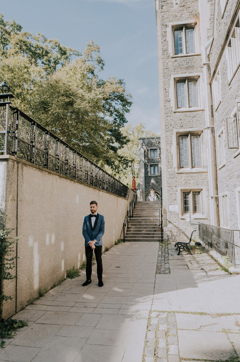 a groom has his back turned to his bride who walks towards him