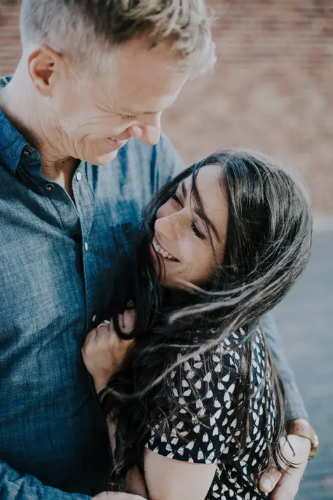 Tender embrace between newly engaged woman and man