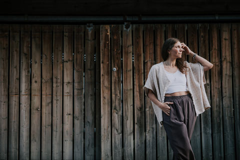 Woman posing against rustic wooden wall for authentic branding portrait