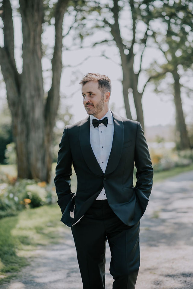 Dave walks in a tux down pathway at the Brighthouse farm