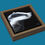 Thumbnail: A small badger acrylic painting on black metal leaf with the badgers head emerging from the shadows, by Sophie Parkhill