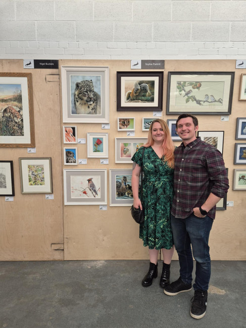 Sophie Parkhill at her Exhibition Wildlife Art display for 2025 with her partner Steve