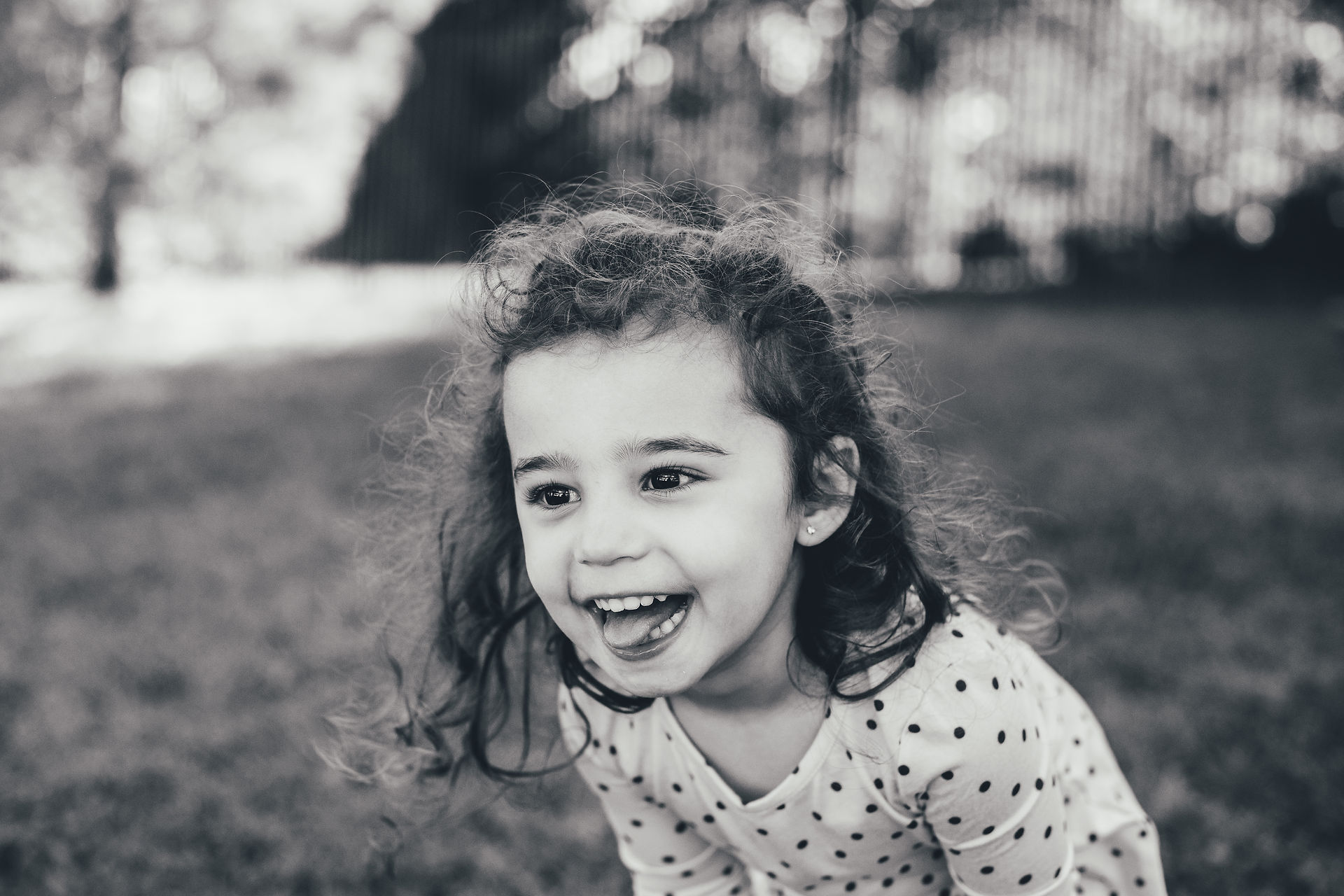 Black and white school portrait of a young girl laughing outdoors