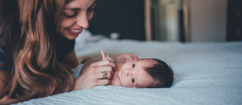 Mother and baby lying on bed