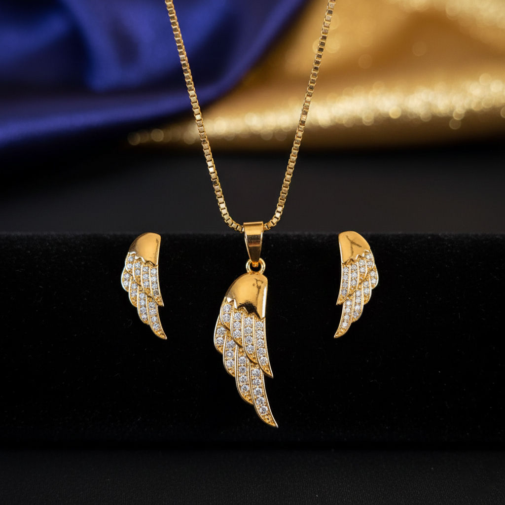 Close-up of Gold Angel Wing Pendant Set featuring a wing pendant and matching stud earrings