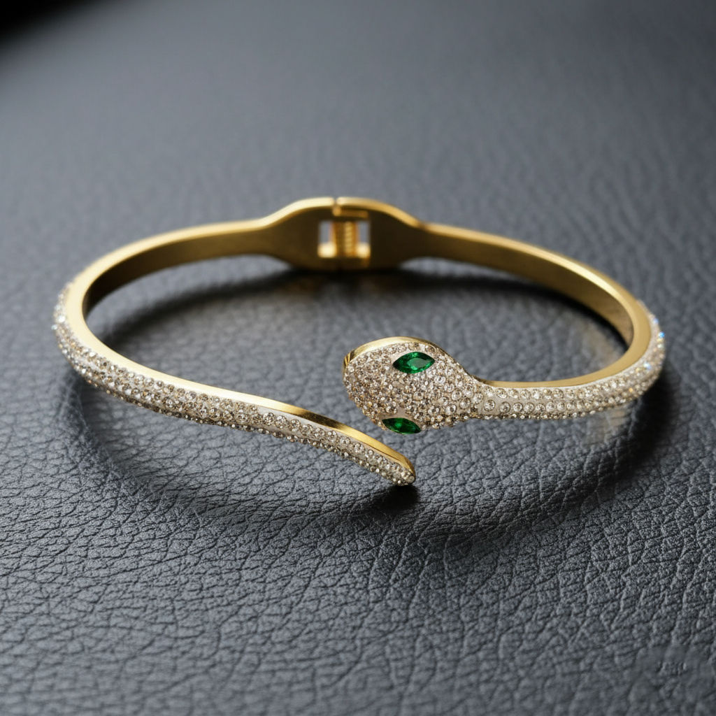 Gold-toned open Kada bracelet for women featuring a serpent motif fully paved with clear crystals and vibrant green eyes