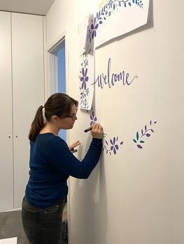 Réalisation d'une couronne florale dessinée à la main sur le mur de l'entrée dans l'appartement d'une cliente à Genève, 2022