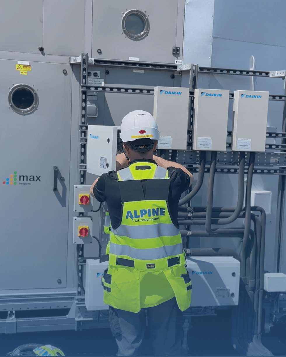 Alpine Air engineer installing a Daikin commercial air conditioning system on-site.
