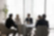 Group of businesspeople negotiating gathered in modern conference room, blurred silhouette