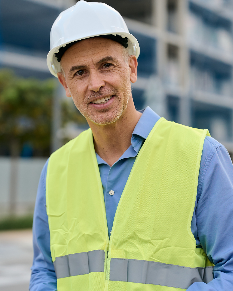 Bauleiter mit Helm und Warnweste auf einer Baustelle für Case Study Hermann Riede Bau