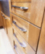 Close-up view of brushed nickel cabinet handles on white kitchen drawers