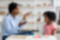 Attractive young african american woman speech therapist working with little black girl, s