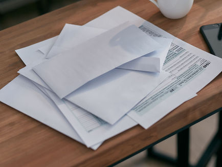 White envelopes and letter on a wooden table. - Credit to Mikhail Nilov on Pexels