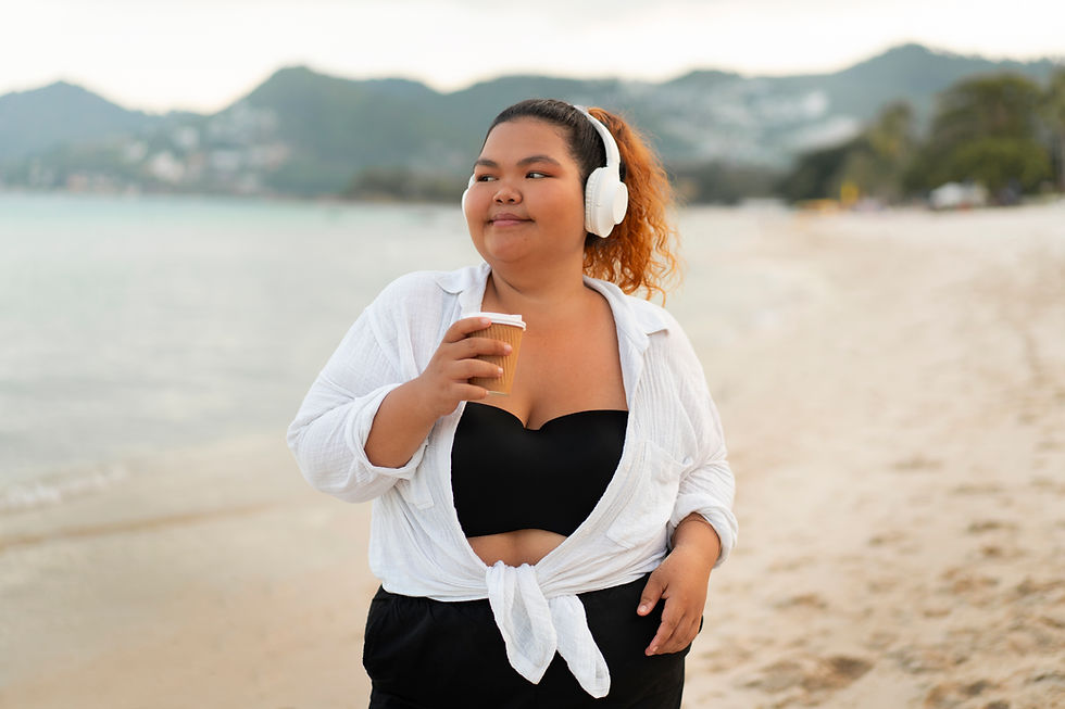 woman with lipedema walking on beach with headphones on