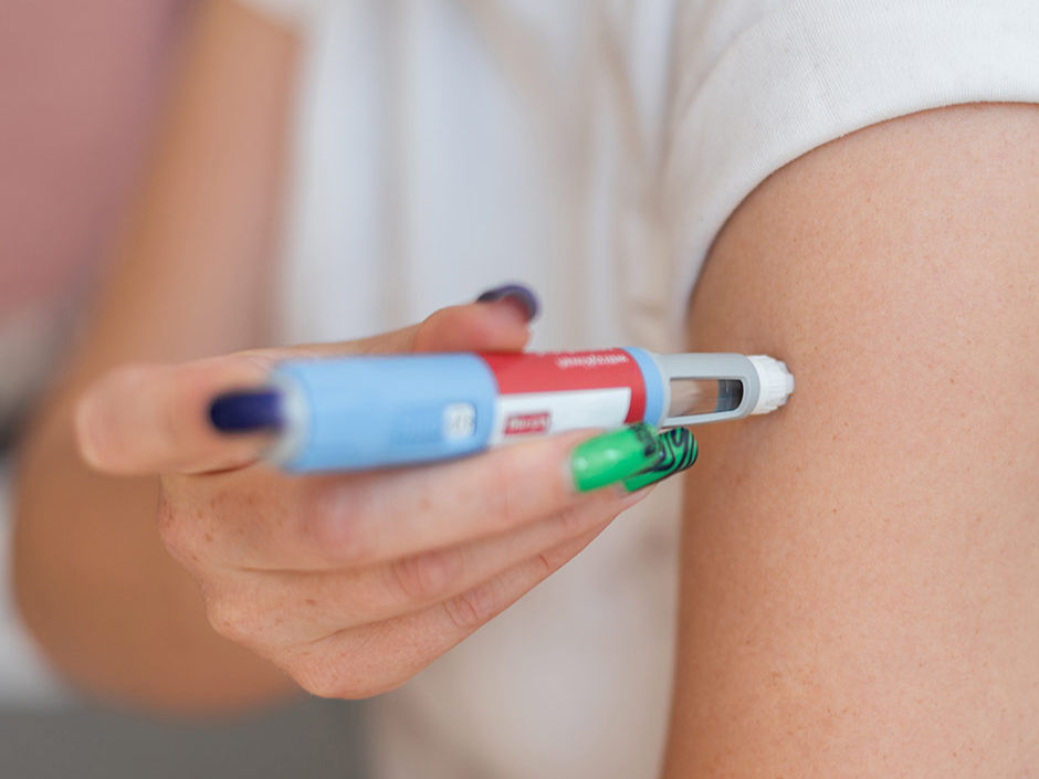 Woman injecting an Ozempic weight loss shot into arm.