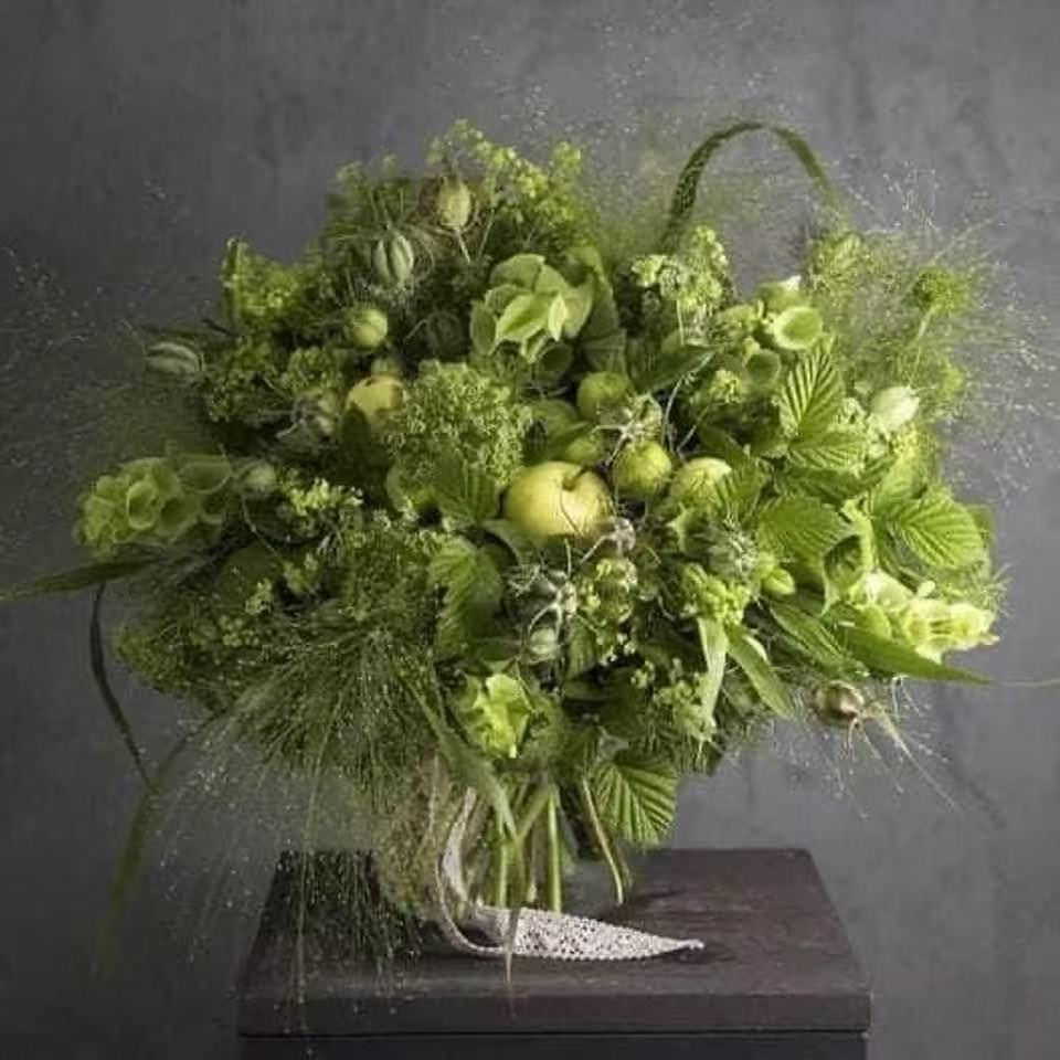 Green monochrome floral arrangement in a vase, portrait photo