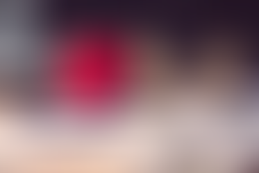 Wooden family figures, stethoscope, and red heart on documents. Background shows a blurred laptop. Mood is caring and health-focused.