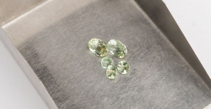 unterschiedlich große oval und rund geschliffene Edelsteine (Turmalin) in blassem grünen mint Farbton.