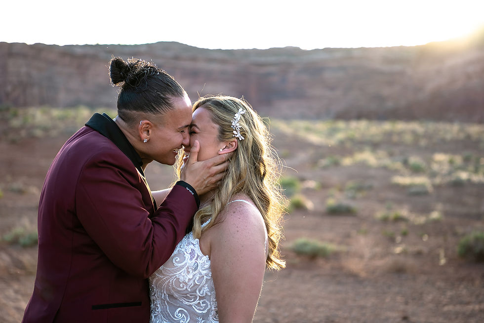 A couple about to kiss and smiling at sunset during their Moab elopement