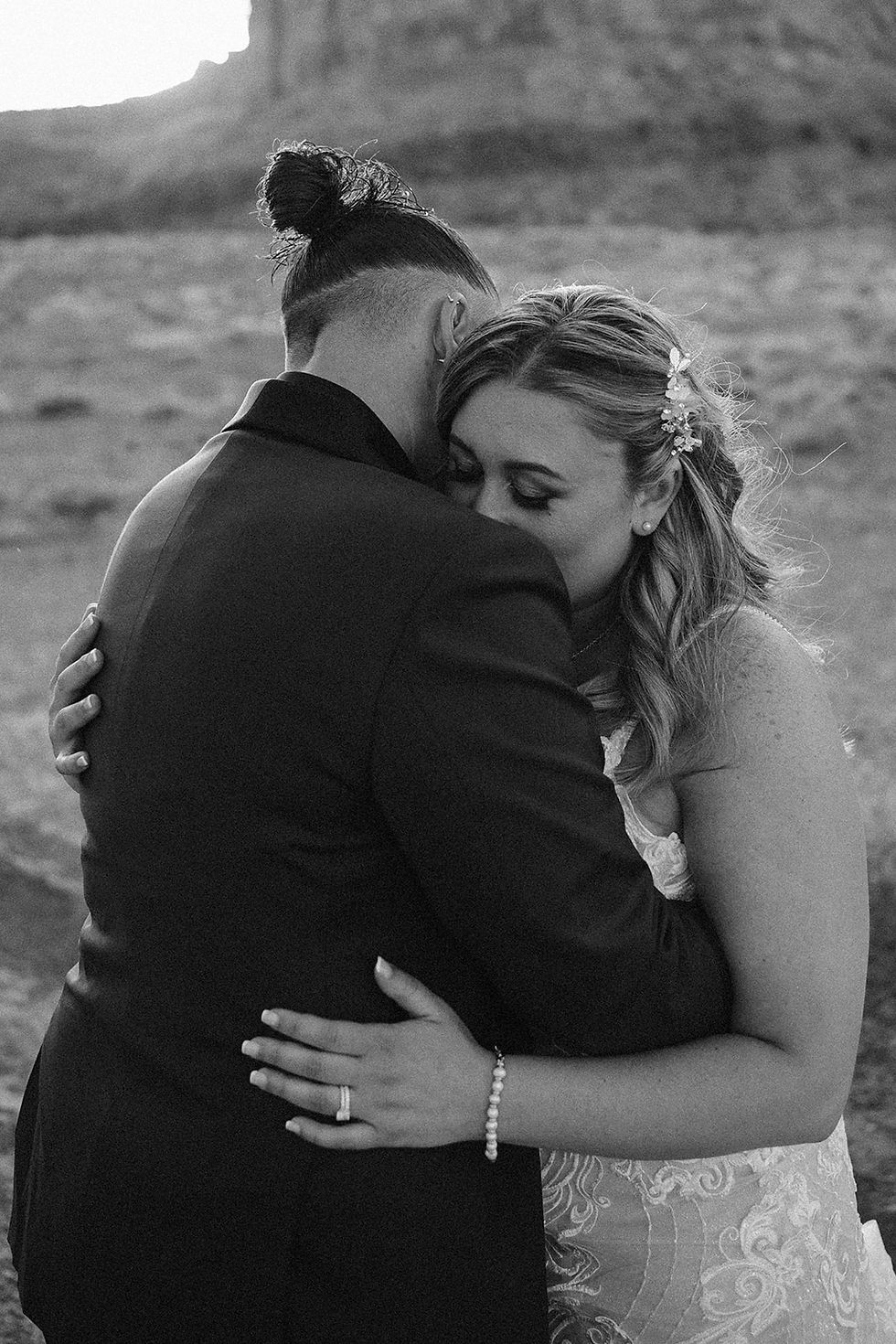 A couple leans in for a soft, emotional hug at sunset during their Moab elopement