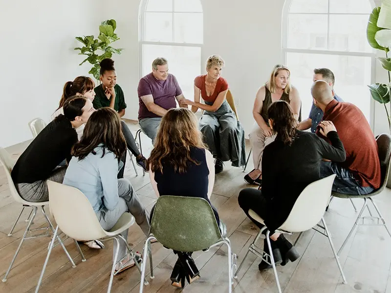 Family members gathered in an Al-Anon meeting, offering mutual support as they cope with the challenges of a loved one’s alcoholism.