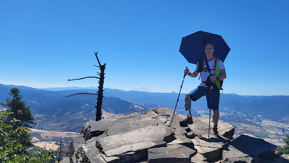 Amputee Outdoors host, Glenn Barfield, posing at Mt. Grizzly viewpoint with Mt. Shasta in the distance.