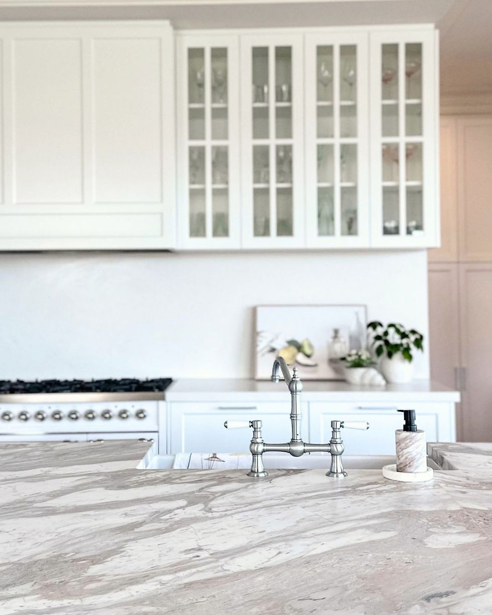 Sleek modern kitchen featuring white cabinetry, blue accent wall, and stainless appliances.