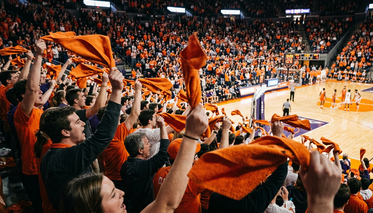 Close-up view of orange rally towels waving above seats in a college basketball arena