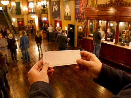 Hands exchanging theater preview ticket