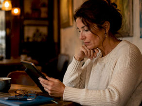Woman reviewing ticket bundles on tablet at kitchen table